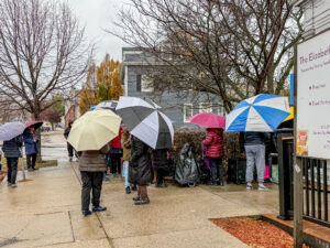 EPH food pantry guests stand in line outside 277 Broadway in Somerville waiting to pick up Thanksgiving dinner provisions.